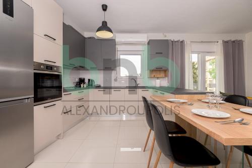 a kitchen with a table with chairs and a counter top at Luxurious Tsimiski 3BDR 3rd Floor in Alexandroupoli