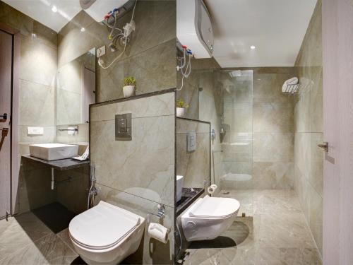 a bathroom with a toilet and a sink and a shower at IVA Premium Aerocity - Free Airport Pickup or Drop in New Delhi