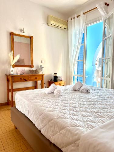 a bedroom with a bed with a mirror and a window at Celeste NAXOS Chora in Naxos Chora