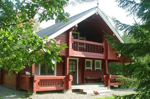 ein großes Holzhaus mit einer Veranda und einer Terrasse in der Unterkunft Loma Rinteelä in Suonenvaara