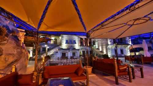 a tent with chairs and tables in front of a building at Harman Cave Hotel in Goreme