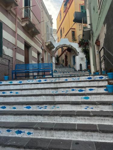 a group of stairs in an alley with blue benches at LE SALINE: beautiful apartment with terrace and splendid view in Carloforte