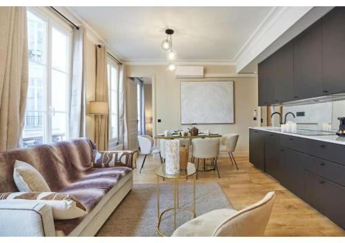 un salon avec un canapé et une cuisine avec une table dans l'établissement Sublim new flat center of Paris Opéra Madeleine, à Paris
