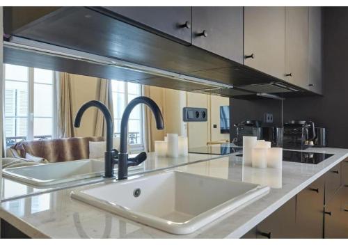 une cuisine avec un évier et un plan de travail dans l'établissement Sublim new flat center of Paris Opéra Madeleine, à Paris
