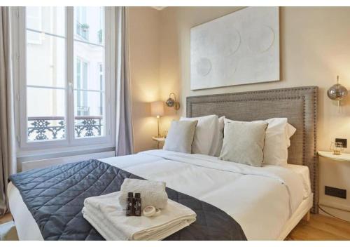 une chambre avec un grand lit avec des serviettes dessus dans l'établissement Sublim new flat center of Paris Opéra Madeleine, à Paris
