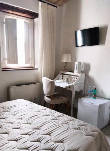 a bedroom with a bed and a desk and a sink at La Casa della Filanda in Belmonte Calabro