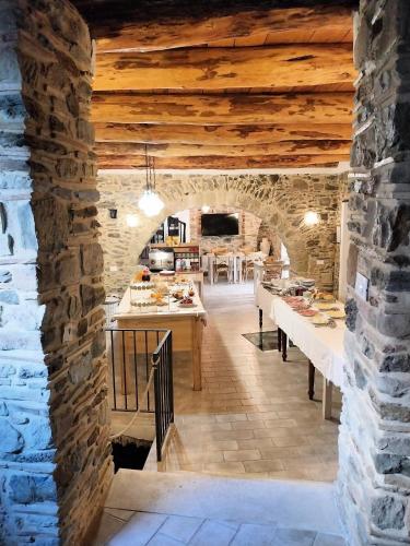 a kitchen with a stone wall and wooden ceilings at La Casa della Filanda in Belmonte Calabro