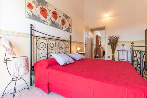 a bedroom with a red bed with a red blanket at Appartamento 1P in Villa De Santis- Gallipoli in Il Monte