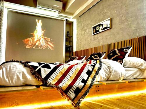 a bed in a room with a fire on the wall at 紬木乃宿-名古屋池下- in Nagoya
