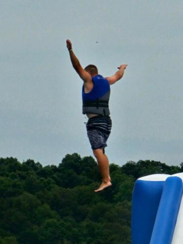 a man jumping in the air with his arms in the air at Crown Lake Resort in Horseshoe Bend