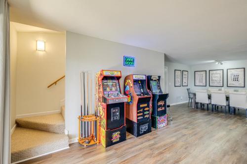 a room with three arcade machines and a table and chairs at Fish, Boat and Hike Lakefront Home with Game Room! in Moneta