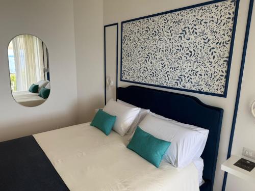 a bedroom with a bed with green pillows and a mirror at Blu Vesuvius Sorrento in Sorrento