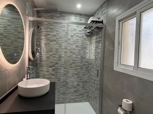 a bathroom with a white sink and a mirror at Hostal Los Mellizos in Conil de la Frontera