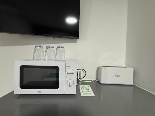 a microwave and a toaster on a counter at Hostal Los Mellizos in Conil de la Frontera