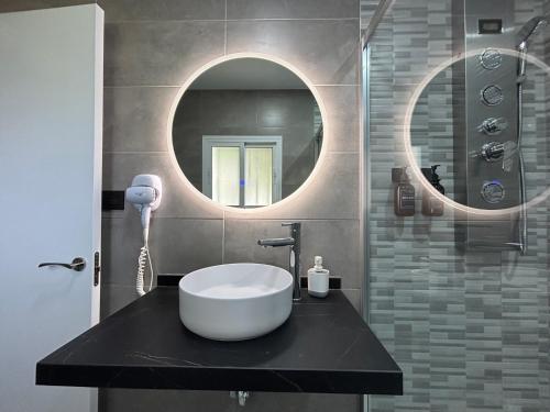 a bathroom with a sink and a mirror at Hostal Los Mellizos in Conil de la Frontera