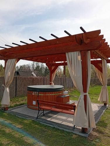 a wooden pavilion with a bench in a park at Domek przy plaży na mazurach in Orzysz