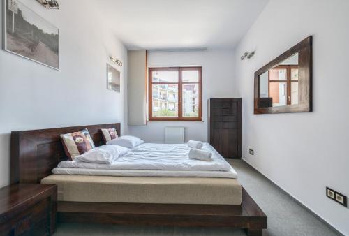 a bedroom with a bed and a window at Neptun Park by NorthSide Apartments in Gdańsk