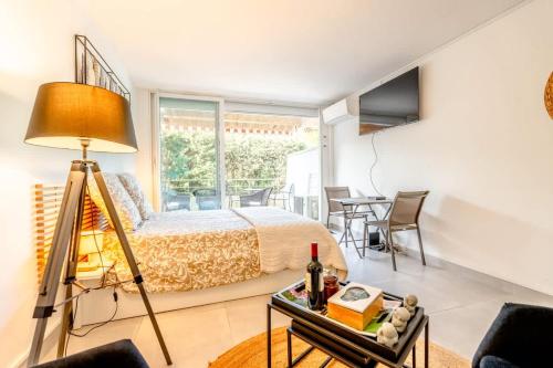 une chambre avec un lit et une table avec une lampe dans l'établissement Petit Eden l Balcony & Peaceful l Shellter Rentals, à Saint-Tropez