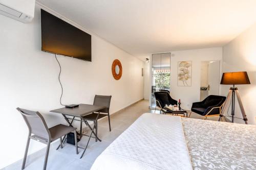 une chambre avec un lit, une table et des chaises dans l'établissement Petit Eden l Balcony & Peaceful l Shellter Rentals, à Saint-Tropez