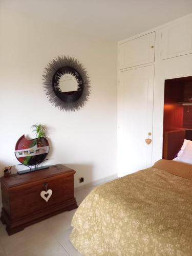 une chambre avec un lit et un miroir au mur dans l'établissement Les Lavandes, à Sanary-sur-Mer