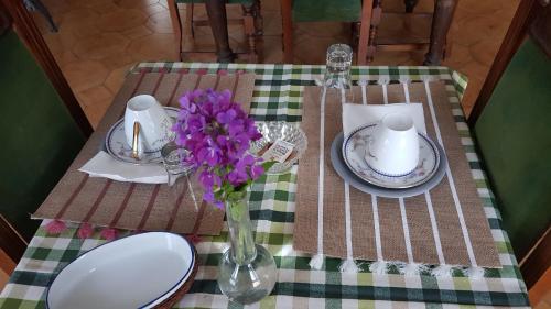 a table with a vase of purple flowers on it at B&B La finestra sul bosco in Serralunga di Crea