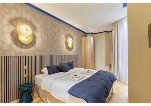 une chambre avec un grand lit avec des oreillers bleus dans l'établissement Incredible AC Apartment 3 bedrooms Center of Paris by Studio Prestige, à Paris
