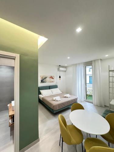 a bedroom with a bed and a table and chairs at I Faraglioni Comfort Rooms in Terrasini