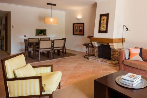 a living room with a couch and a fireplace at Birdsong Vila Sol Village in Vilamoura