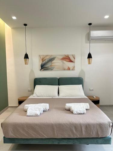 a bedroom with a bed with two towels on it at I Faraglioni Comfort Rooms in Terrasini