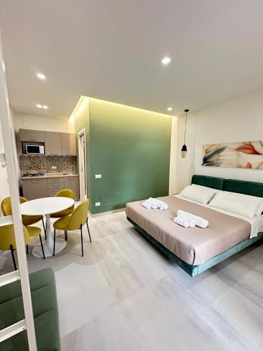 a bedroom with a bed and a table and a kitchen at I Faraglioni Comfort Rooms in Terrasini