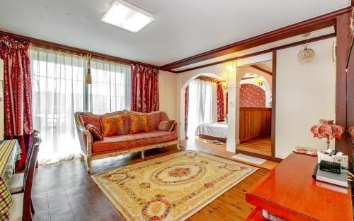 a living room with a couch and a bedroom at Spa Pension Basso in Sokcho