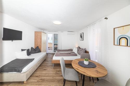 a hotel room with two beds and a table at Apartman Simic in Trogir