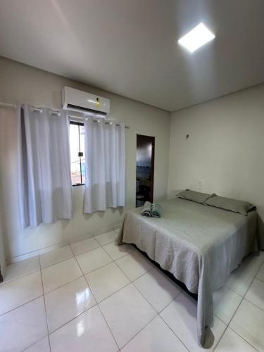 un dormitorio con una cama y una ventana en Aconchego, en Santarém