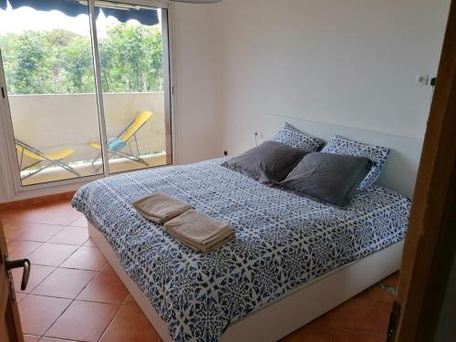 une chambre avec un lit et une fenêtre avec une chaise dans l'établissement L'idéal entre centre ville, mer et colline, à Toulon