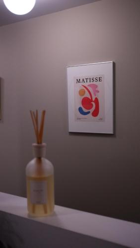 a vase on a table with a sign on a wall at Maison Saint-Vincent By Maisons & co in Montréal