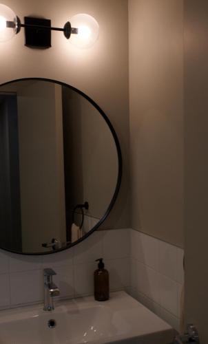 a bathroom with a mirror and a sink at Maison Saint-Vincent By Maisons & co in Montréal