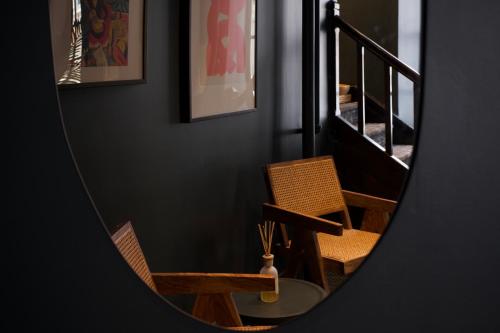 a mirror reflection of two chairs and a staircase at Maison Saint-Vincent By Maisons & co in Montréal