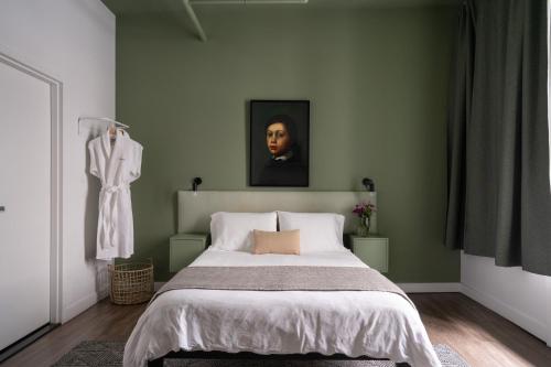 a bedroom with a bed and a painting on the wall at Maison Saint-Vincent By Maisons & co in Montréal