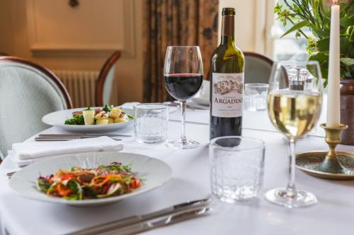 a table with a bottle of wine and a plate of food at The Arundell in Lifton