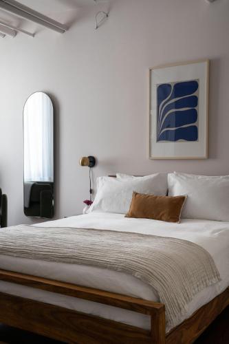 a bedroom with a large bed with white sheets at Maison Saint-Vincent By Maisons & co in Montréal