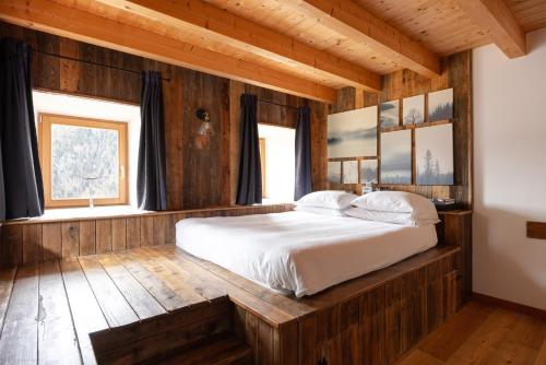a bedroom with a bed in a wooden house at Studio Ebi Vacation - Alleghe - Monte Civetta in Alleghe