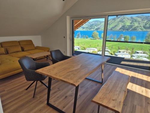 a living room with a table and chairs and a large window at Sunset am Attersee in Nussdorf am Attersee