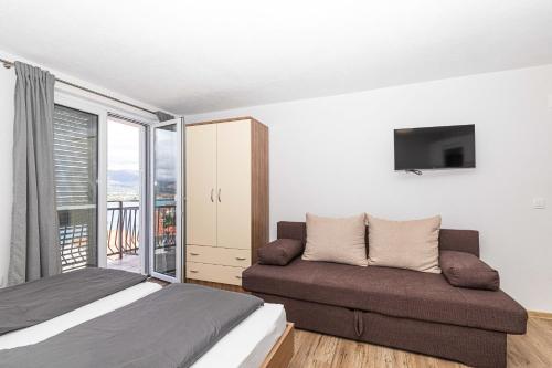 a bedroom with a bed and a couch at Apartman Simic in Trogir