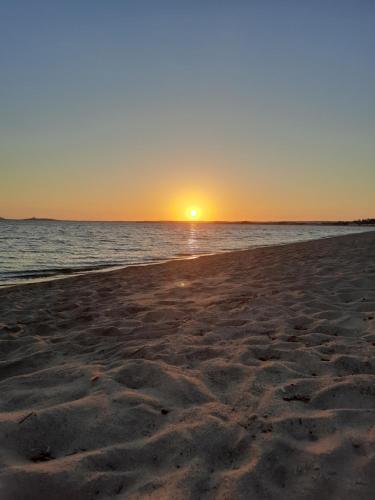 a sunset on a beach with the ocean at Casa della Lavanda Apartment in Oristano