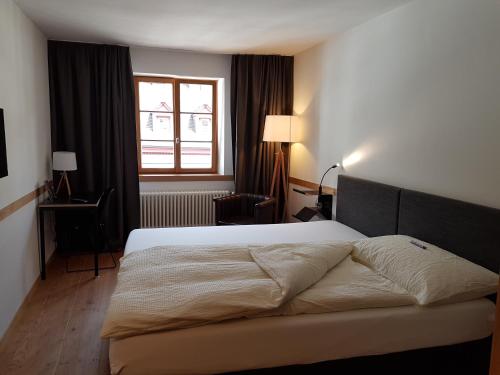Un dormitorio con una cama grande y una ventana en East West Hotel Basel, en Basilea