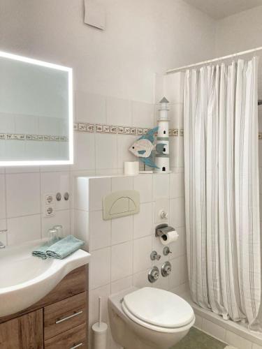 a white bathroom with a toilet and a sink at Fewo - Am Mühlenteich in Wismar
