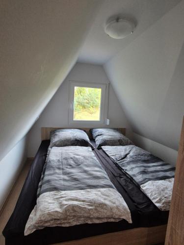 two beds in a room with a window at Ferienhaus am Helenesee 14 in Frankfurt Oder