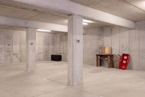 an empty room with concrete pillars and a red suitcase at Studio Ebi Vacation - Alleghe - Monte Civetta in Alleghe
