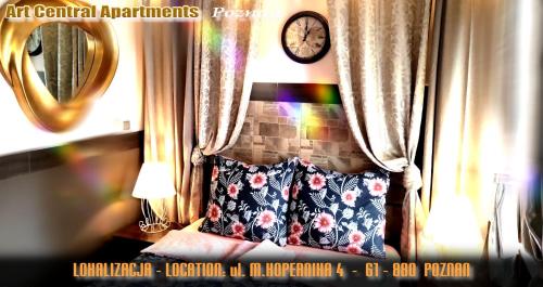 a bedroom with a pillow and a clock on a wall at Art Apartments in Poznań