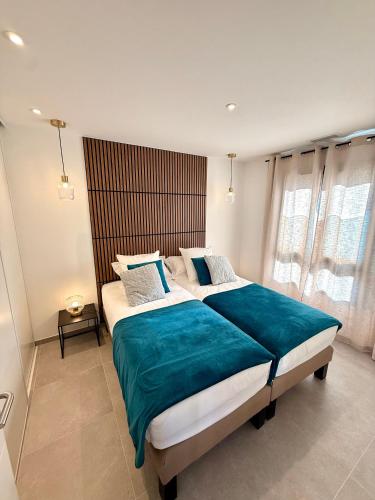 une chambre avec un grand lit avec une couverture bleue dans l'établissement Résidence Collioure le Haut, à Collioure